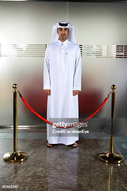 profile of a gulf arab man standing behind a stanchion. - stanchion stock pictures, royalty-free photos & images