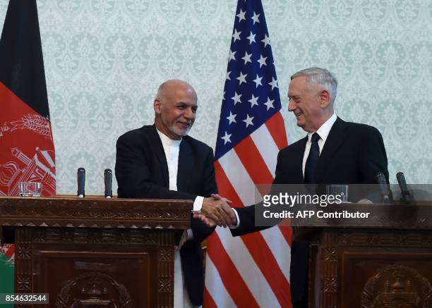 Defense Secretary Jim Mattis shakes hands with Afghan President Ashraf Ghani after a press conference at the Presidential Palace in Kabul on...