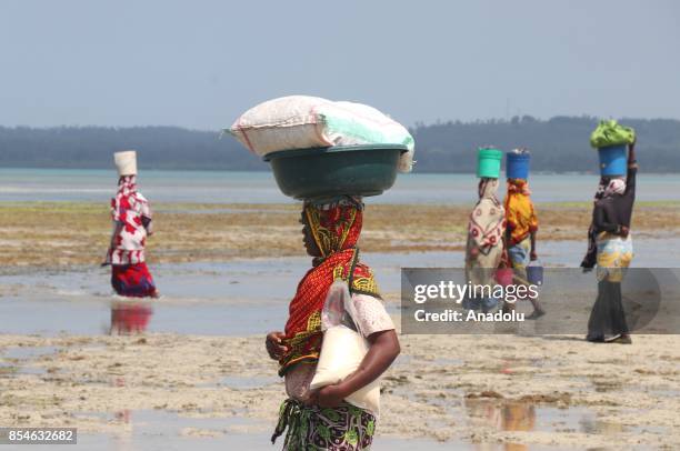 Tanzanian women carry buckets on their heads in Zanzibar, Tanzania on September 26, 2017. Tanzania's semi-autonomous archipelago of Zanzibar was the...