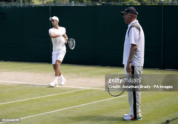 Serbia's Novak Djokovic practices watched by coach Boris Becker during day eleven of the Wimbledon Championships at the All England Lawn Tennis and...