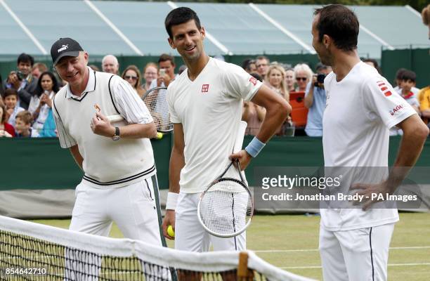 Novak Djokovic along with Boris Becker and Radek Stepanek takes part in a practice session during day thirteen of the Wimbledon Championships at the...