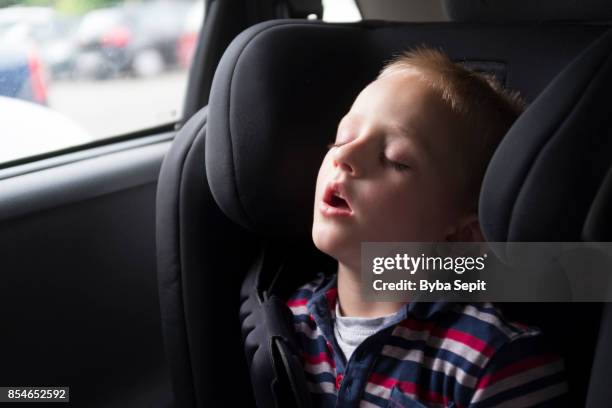 little boy sleeps in car seat inside a car. - presov stock pictures, royalty-free photos & images