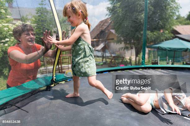 little girl touches hands with her grandmother. - family sports centre laughing stock pictures, royalty-free photos & images