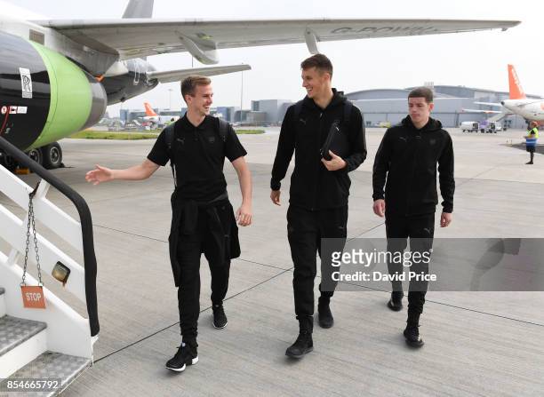 Rob Holding, Matt Macey and Charlie Gilmour of Arsenal board the plane at Luton Airport on September 27, 2017 in Luton, England.
