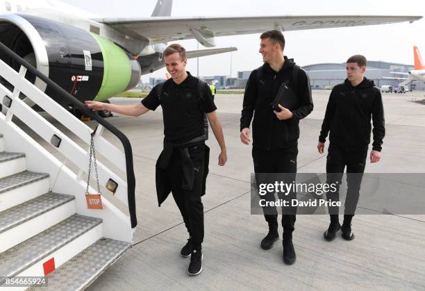 Rob Holding, Matt Macey and Charlie Gilmour of Arsenal board the plane at Luton Airport on September 27, 2017 in Luton, England.