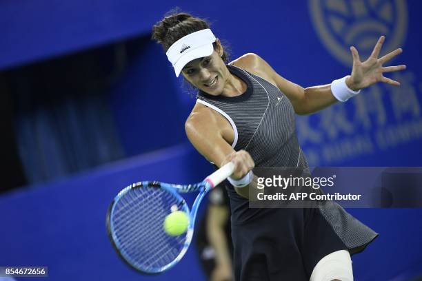 Garbine Muguruza of Spain hits a return against Magda Linette of Poland during their third round women's singles match at the WTA Wuhan Open tennis...
