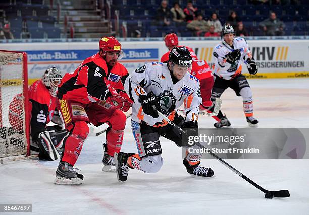 Chris Herperger of Hannover and Sebastian Furchner of Wolfsburg fight for the puck during the DEL Play-Off game between Hannover Scorpions and...