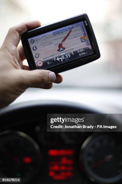 Man uses a satellite Navigator in his car. The sat nav system s a system of satellites that provide autonomous geo-spatial positioning with global...