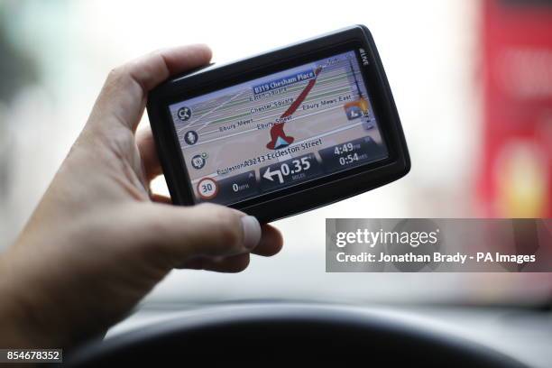 Man uses a satellite Navigator in his car. The sat nav system s a system of satellites that provide autonomous geo-spatial positioning with global...