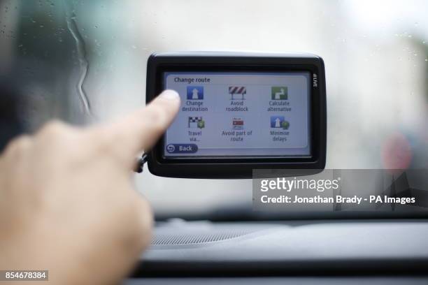 Man uses a satellite Navigator in his car. The sat nav system s a system of satellites that provide autonomous geo-spatial positioning with global...