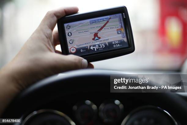 Man uses a satellite Navigator in his car. The sat nav system s a system of satellites that provide autonomous geo-spatial positioning with global...