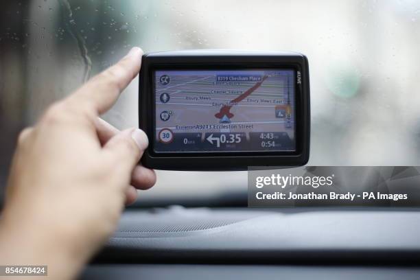 Man uses a satellite Navigator in his car. The sat nav system s a system of satellites that provide autonomous geo-spatial positioning with global...