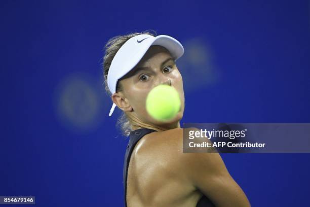 Magda Linette of Poland hits a return against Garbine Muguruza of Spain during their third round women's singles match at the WTA Wuhan Open tennis...