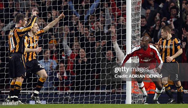 Hull City's Andy Dawson looks at the ball while his teammates Bryan Hughes and Kamil Zayatte gesture to the linesman for offside after Arsenal's...