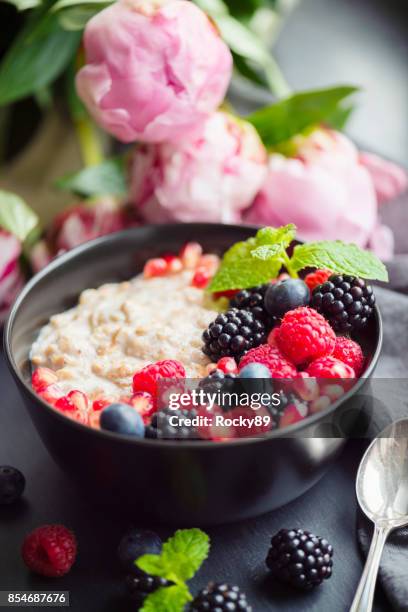 healthy organic porridge topped with berries - oatmeal stock pictures, royalty-free photos & images