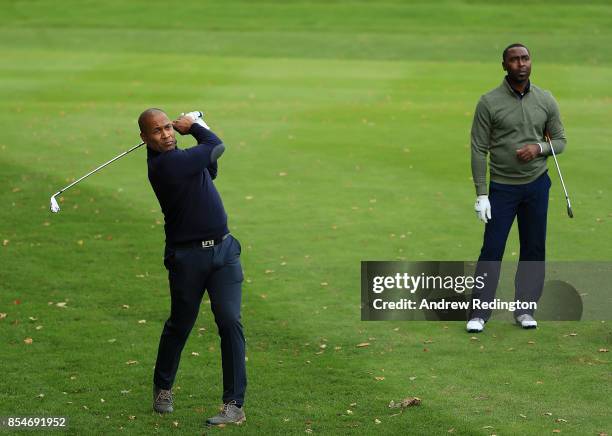 Former footballer Les Ferdinand plays a shot as Andy Cole looks on during the pro am ahead of the British Masters at Close House Golf Club on...
