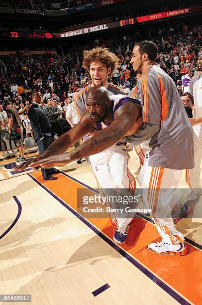 Shaquille O'Neal of the Phoenix Suns does his Superman impression with the help of teammates Robin Lopez and Courtney Sims prior to the game against...