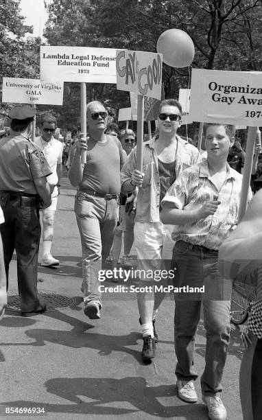 Groups of activists march down the streets of Greenwich Village, NYC with signs held high during the 1989 Gay Pride Parade commemorating the 20th...