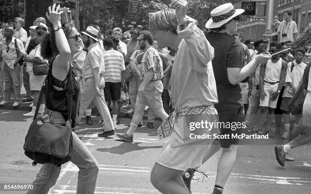 Woman holding a radio over her head, and a man dance in the middle of the street, during the 1989 Gay Pride Parade in Greenwich Village, Manhattan...