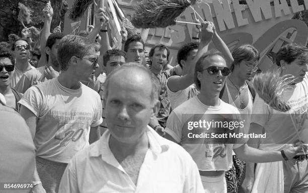 Gay rights activists march in Greenwich Village, Manhattan, at the 1989 Gay Pride Parade commemorating the 20th anniversary of the Stonewall Riots .