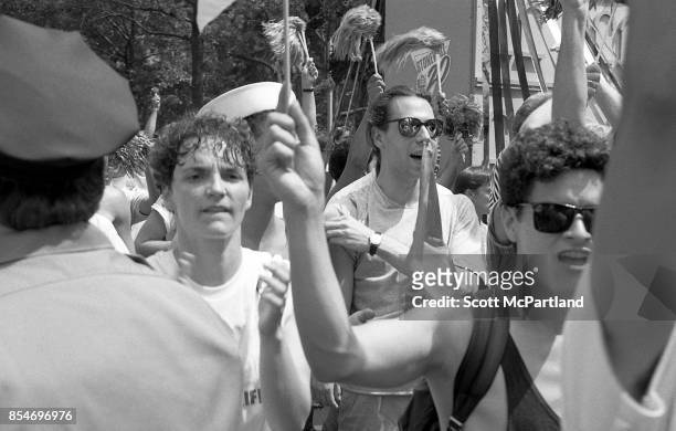 Gay rights activists march in Greenwich Village, Manhattan, at the 1989 Gay Pride Parade commemorating the 20th anniversary of the Stonewall Riots .