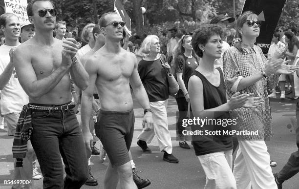 Gay rights activists march in Greenwich Village, Manhattan, at the 1989 Gay Pride Parade commemorating the 20th anniversary of the Stonewall Riots .