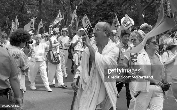 Gay rights activists march in Greenwich Village, Manhattan, at the 1989 Gay Pride Parade commemorating the 20th anniversary of the Stonewall Riots .