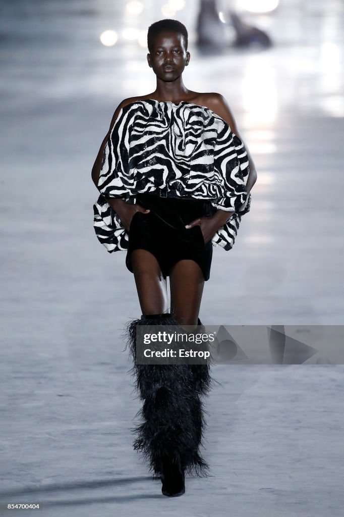 A model walks the runway during the Saint Laurent show as part of the ...