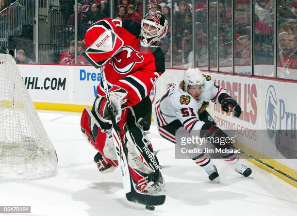Goaltender Martin Brodeur of the New Jersey Devils clears the puck against Brian Campbell of the Chicago Blackhawks at the Prudential Center on March...