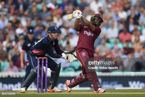 Evin Lewis of West Indies hits a six as wicketkeeper Jos Buttler of England looks on during the 4th Royal London One Day International between...