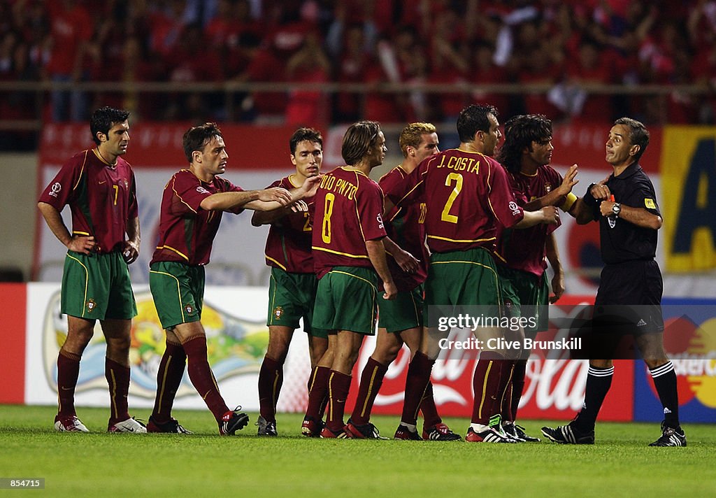 The Portugal team argue with referee Angel Sanchez of Argentina after he gave a red card to team-mate Joao Pinto