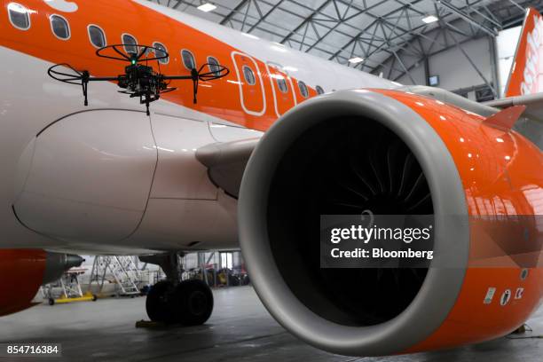 An unmanned aerial vehicle flies around an Airbus SE A320 Neo passenger aircraft during a demonstration of the Remote Automated Plane Inspection and...