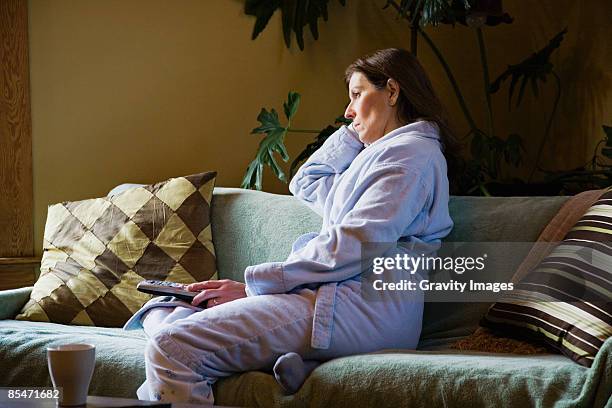 woman watching morning television wearing pajamas - woman lonely stock pictures, royalty-free photos & images