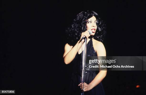 March 26: 'Queen of Disco' Donna Summer performs onstage in a slinky black dress at the Civic Center on March 26, 1978 in Atlanta, Georgia.