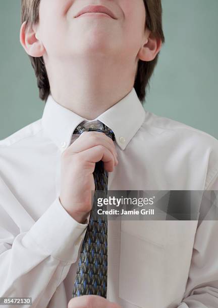 young boy tightening his tie - school tie stock pictures, royalty-free photos & images
