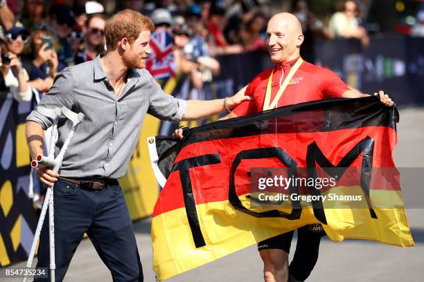 Prince Harry congratulates bronze medalist Thomas Stuber of Germany after competing in Cycling Time Trial during the Invictus Games 2017 at High Park...