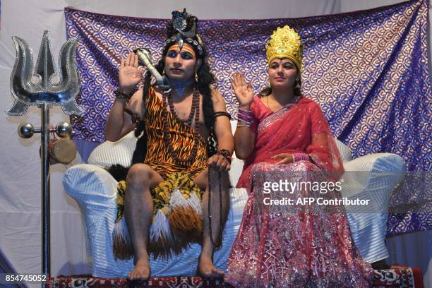 Indian artists dressed as Hindu Lord Shiva and Parvati perform during the 'Ramleela', the story of Lord Rama, ahead of the Hindu festival of Dussehra...