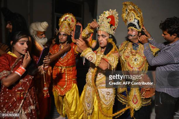 Indian artists dressed as Hindu Lord Rama , Sita , Laxman and Ravan put on their make-up before performing the 'Ramleela', the story of Lord Rama,...