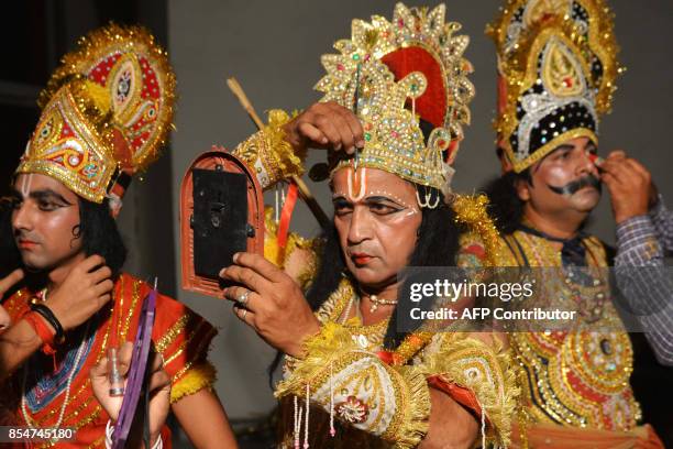 Indian artists dressed as Hindu Lord Rama , Laxman and Ravan put on their make-up before performing the 'Ramleela', the story of Lord Rama, ahead of...