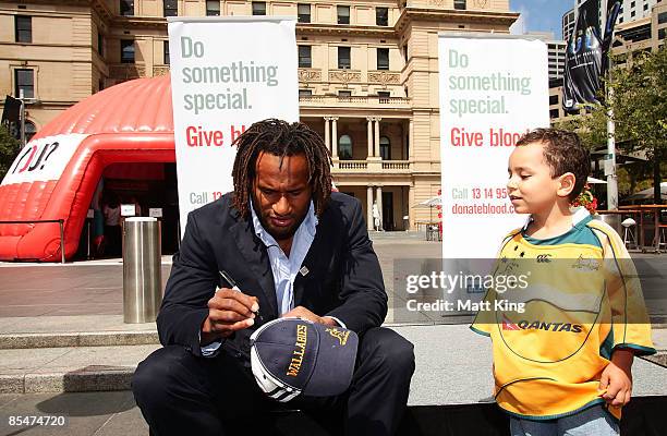 Waratahs and Wallabies player Lote Tuqiri signs an autograph for a young fan during a visit to the Australian Red Cross 'Year of the Blood Donor 2009...