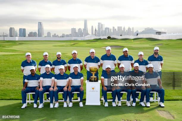 The International Team poses for a group photo with the Presidents Cup trophy prior to the start of the Presidents Cup at Liberty National Golf Club...