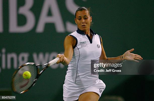 Flavia Pennetta of Italy returns a forehand to Ana Ivanovic during the BNP Paribas Open at the Indian Wells Tennis Garden on March 17, 2009 in Indian...
