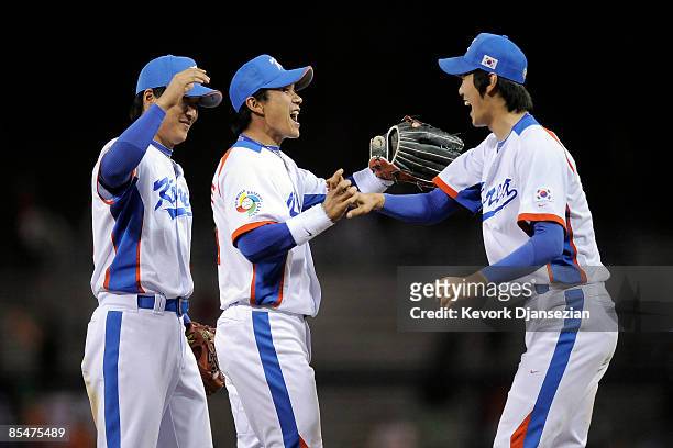 Jin Young Lee of Korea celebrates with teammates Jong Wook Lee and Kwanghyun Kim after winning against Japan during the 2009 World Baseball Classic...