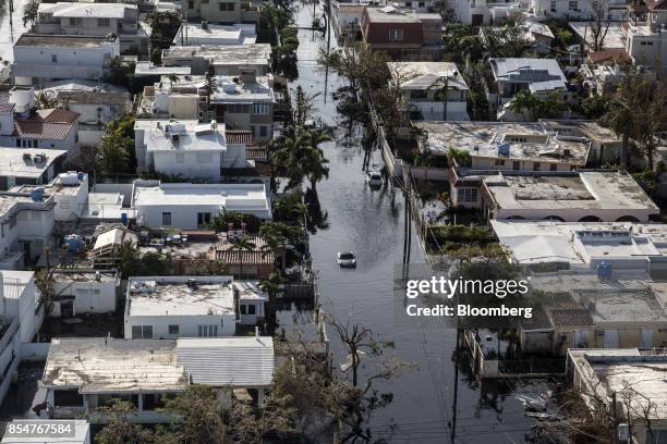 Vehicle drives through streets filled with floodwater near destroyed homes from Hurricane Maria in this aerial photograph taken above Barrio Obrero...
