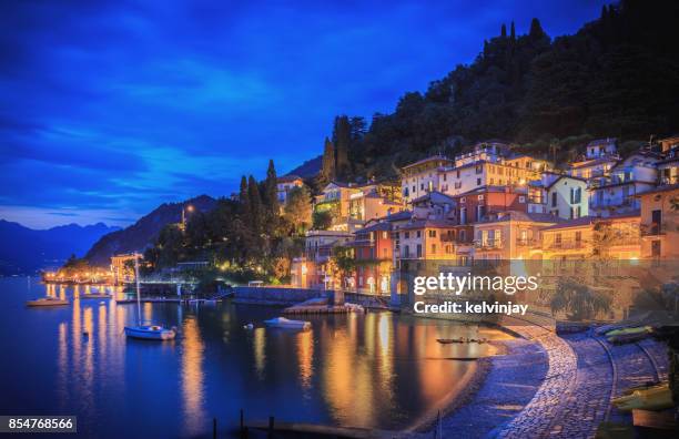 varenna on the shore of lake como, italy, showing houses, bars and restaurants in the evening. - lake como stock pictures, royalty-free photos & images