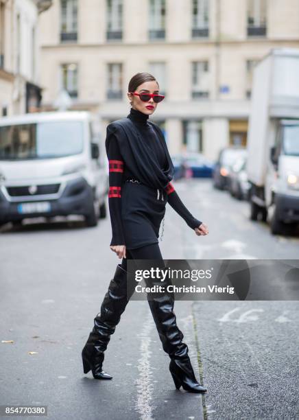 Olivia Culpo wearing a black turtleneck top Aquilano Rimondi, a black dress Carmen March with belt, Wolford black tights, Yves Saint Laurent boots,...