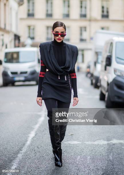 Olivia Culpo wearing a black turtleneck top Aquilano Rimondi, a black dress Carmen March with belt, Wolford black tights, Yves Saint Laurent boots,...