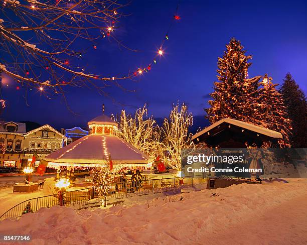 town, in snow,  decorated with holiday lights. - leavenworth washington stock pictures, royalty-free photos & images