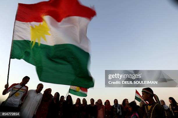 Syrian Kurds wave the Kurdish flag, in the northeastern Syrian city of Qamishli on September 27 during a gathering in support of the independence...