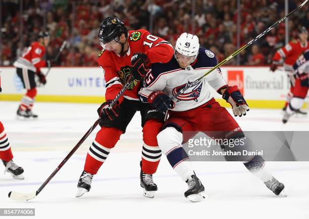 Patrick Sharp of the Chicago Blackhawks is pressured by Lukas Sedlak of the Columbus Blue Jackets as he advances the puck during a preseason game at...